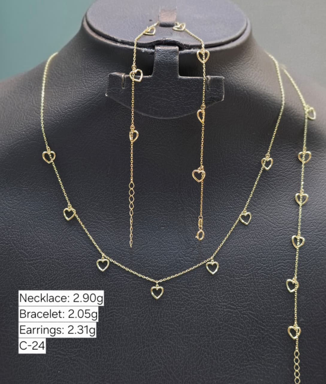 Gold necklace on a black mannequin with weight information displayed.