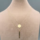 Gold necklace with a green pendant on a mannequin neck, labeled with weight and code.