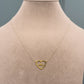 Gold necklace with a heart-shaped pendant on a mannequin.