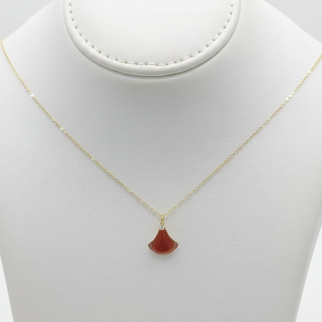 Necklace with a red pendant on a beige mannequin bust against a white background
