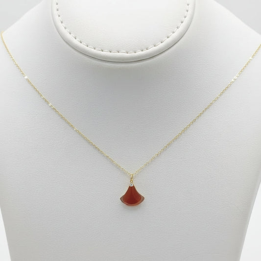Necklace with a red pendant on a beige mannequin bust against a white background