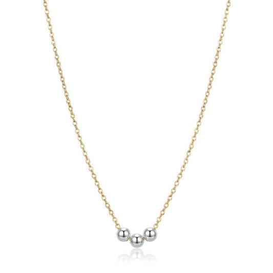 Gold necklace with three silver beads on a white background