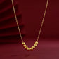 Gold necklace with round beads on a red background