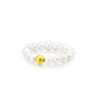 Pearl bracelet with a gold bead on a white background