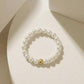 Pearl bracelet with a gold bead on a light beige background