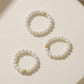 Set of pearl earrings with gold accents on a light background