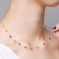 Colorful beaded necklace being adjusted on a person's neck against a neutral background