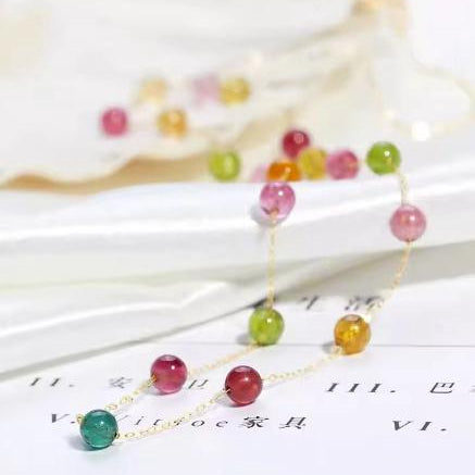 Colorful beaded necklace on a white surface with blurred background