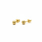Gold earring on a digital scale with a wooden surface and white towel in the background