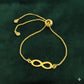 Gold bracelet with an infinity symbol on a green background
