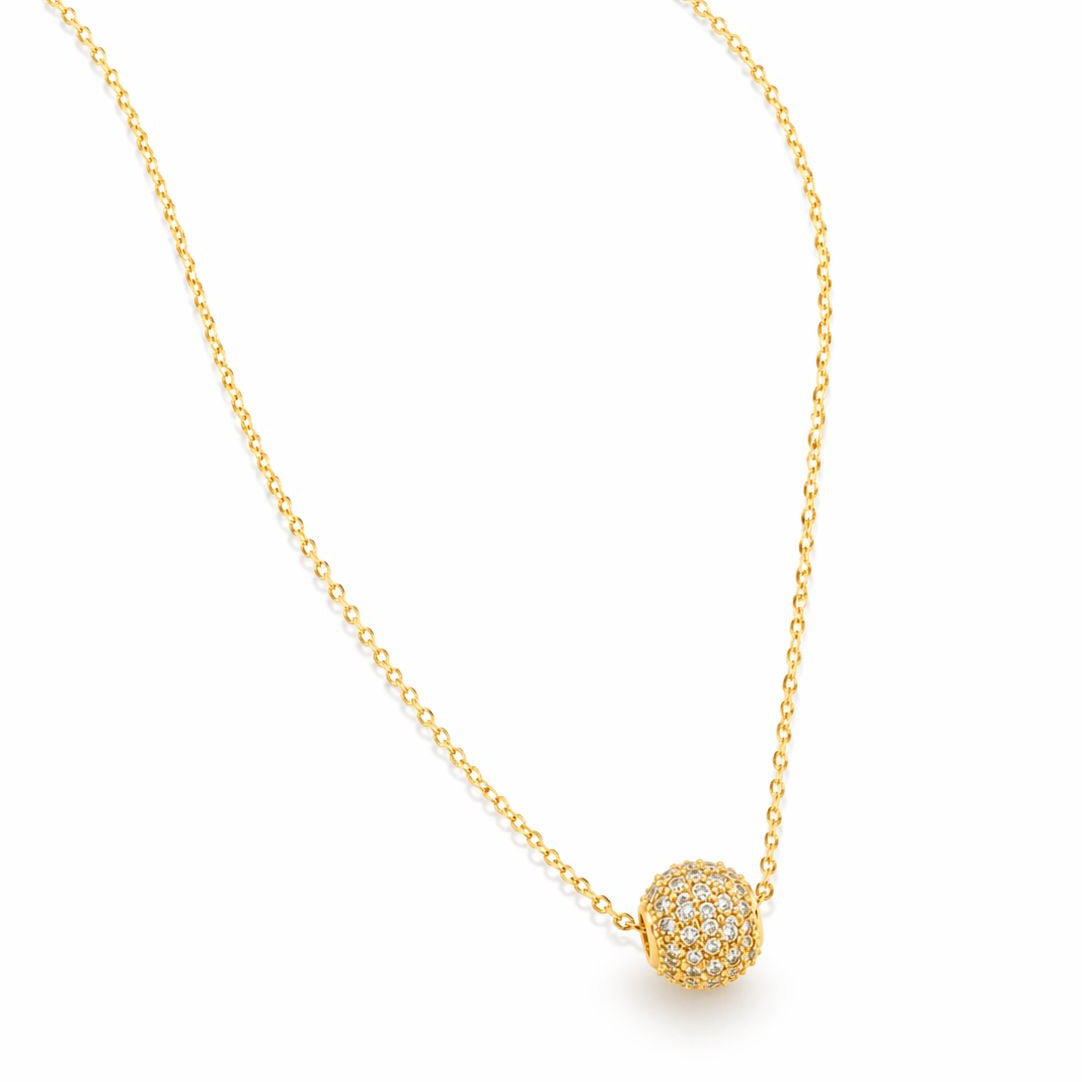 Gold necklace with a round, diamond-studded pendant on a white background