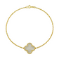 Gold bracelet with a clover-shaped charm on a white background