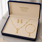 Gold jewelry set including necklace, bracelet, and earrings in an 'Embellish' box.