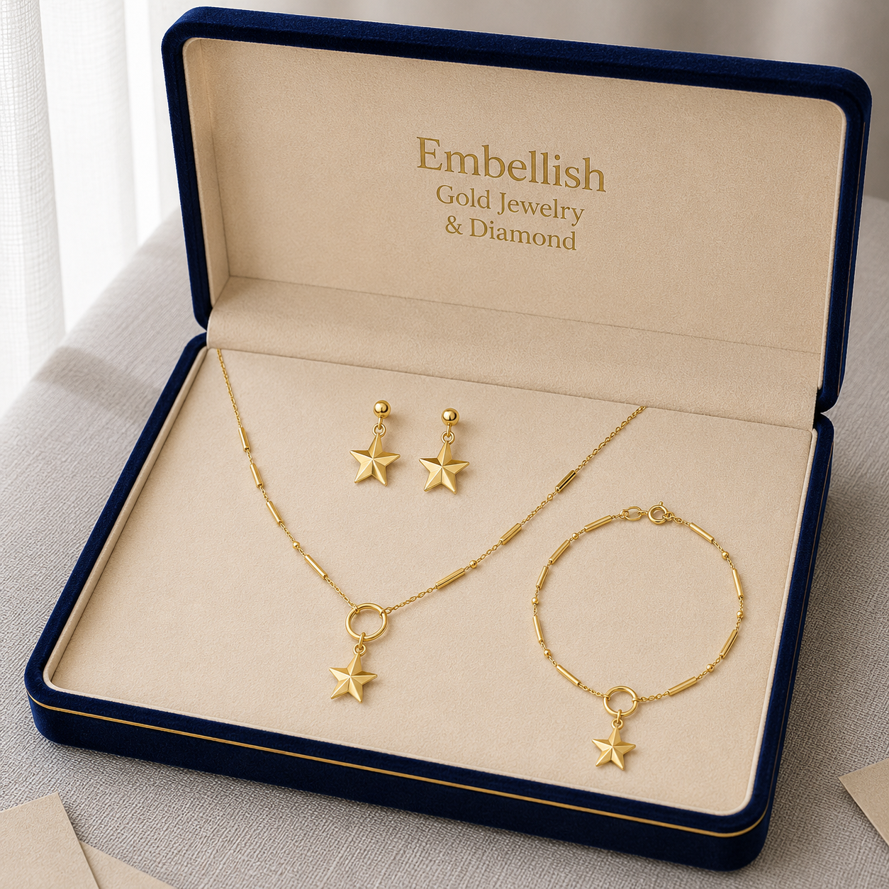 Gold jewelry set including necklace, bracelet, and earrings in an 'Embellish' box.