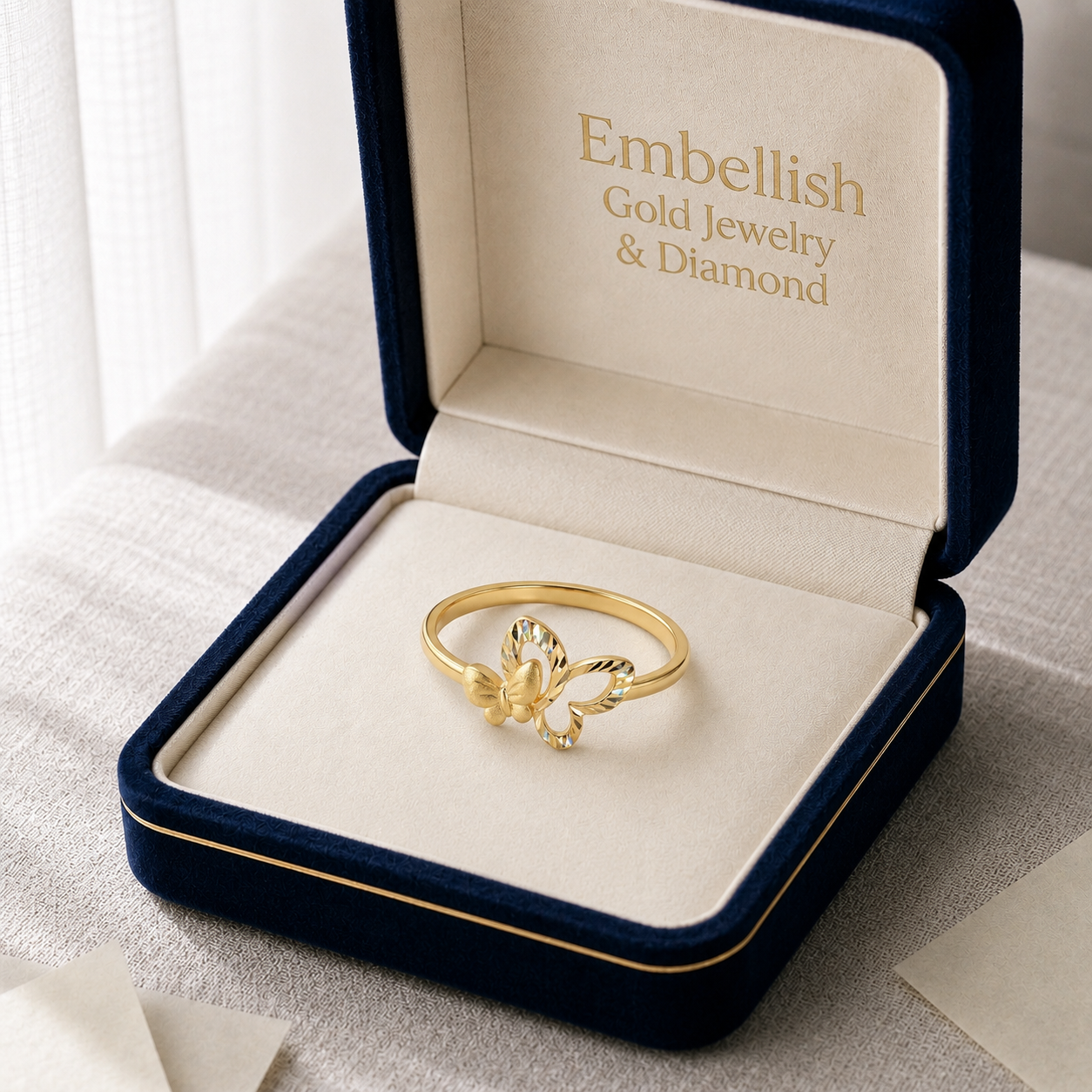 Gold ring in a 'Embellish Gold Jewelry & Diamond' box on a light background