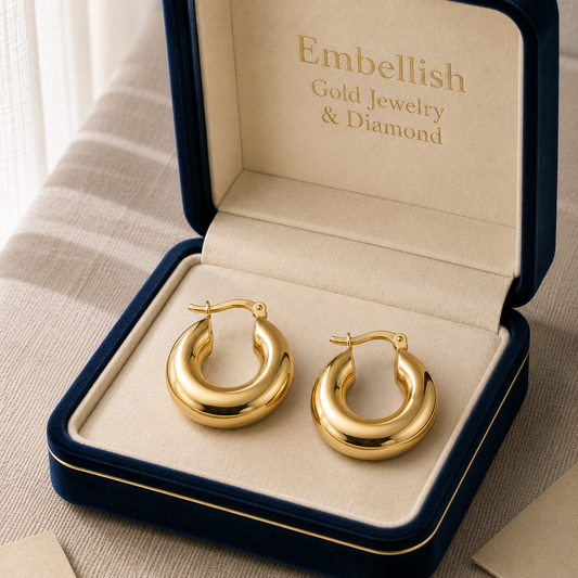 Gold hoop earrings in a 'Embellish Gold Jewelry & Diamond' box on a neutral background
