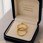 Gold hoop earrings in a 'Embellish Gold Jewelry & Diamond' box on a light background