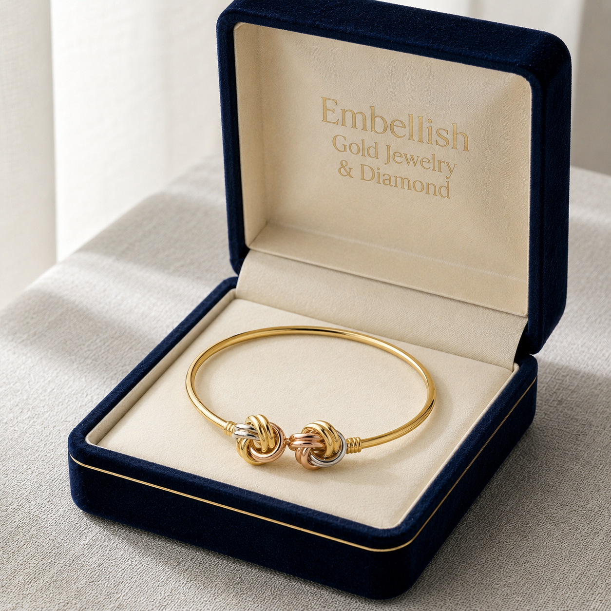 Gold bracelet in a 'Embellish Gold Jewelry & Diamond' box on a light background
