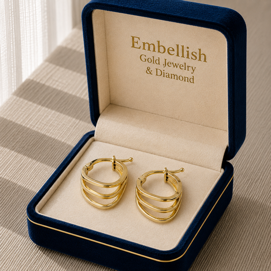 Gold hoop earrings in a 'Embellish Gold Jewelry & Diamond' box on a textured surface.