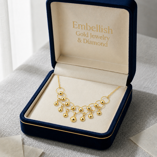 Gold necklace in an open jewelry box with 'Embellish Gold Jewelry & Diamond' branding.