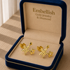 Gold star-shaped earrings in a 'Embellish' jewelry box.