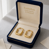 Gold hoop earrings in a 'Embellish Gold Jewelry & Diamond' box on a light gray surface.