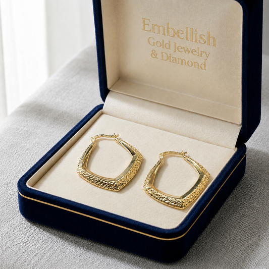 Gold hoop earrings in a 'Embellish Gold Jewelry & Diamond' box on a gray surface.