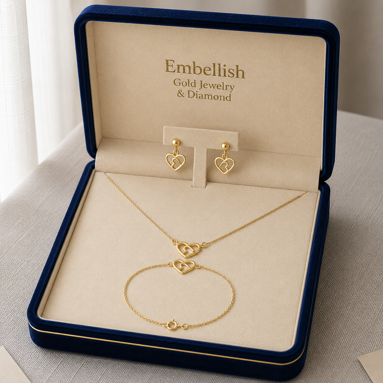 Gold jewelry set including necklace and earrings in an 'Embellish' box.