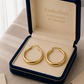 Gold hoop earrings in a 'Embellish Gold Jewelry & Diamond' box.