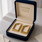 Gold hoop earrings in a 'Embellish Gold Jewelry & Diamond' box on a light surface.