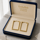 Gold earrings in a 'Embellish Gold Jewelry & Diamond' box on a neutral background